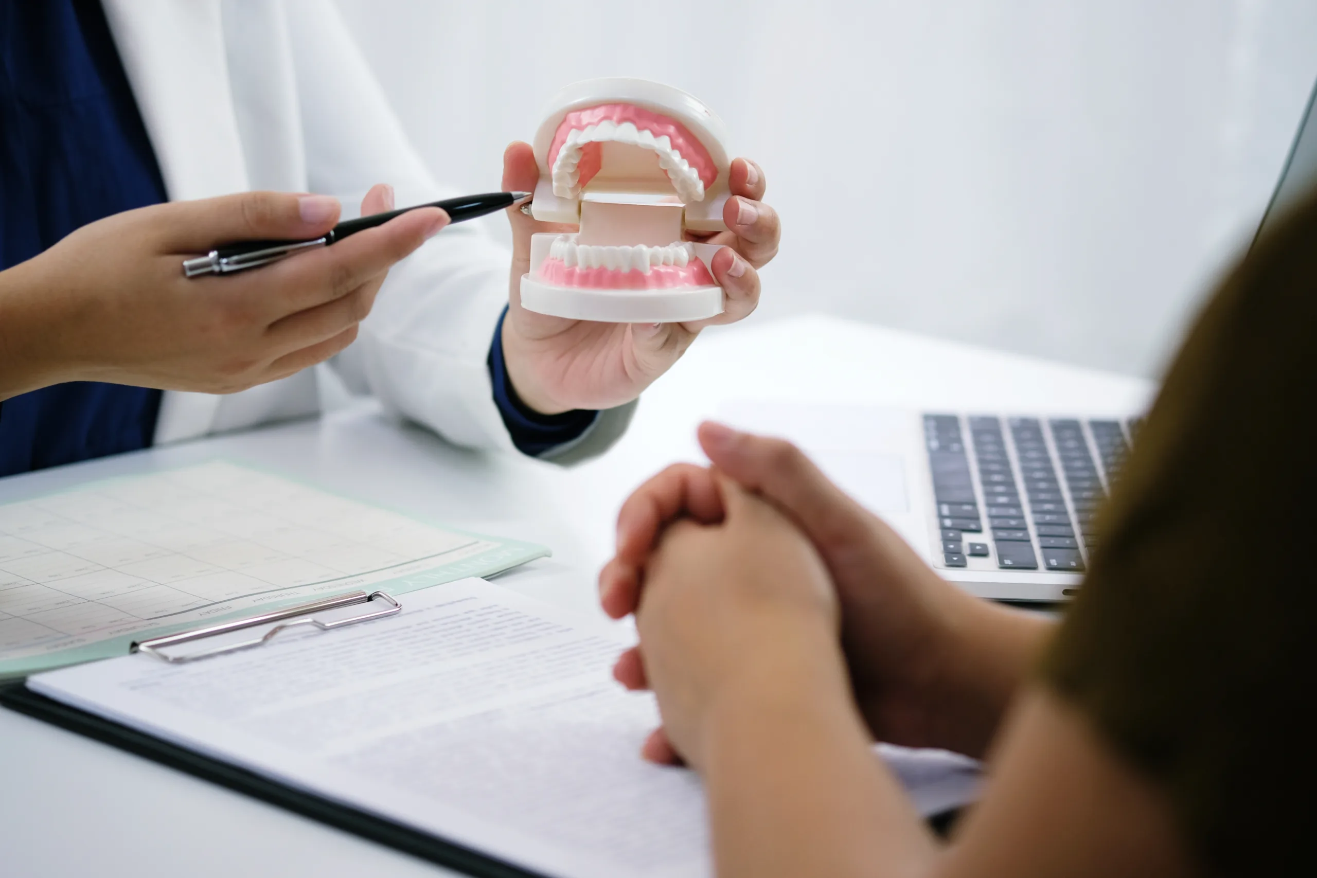How to Care for Your Dentures: A Complete Maintenance Guide dentist with dentures explaining to patient